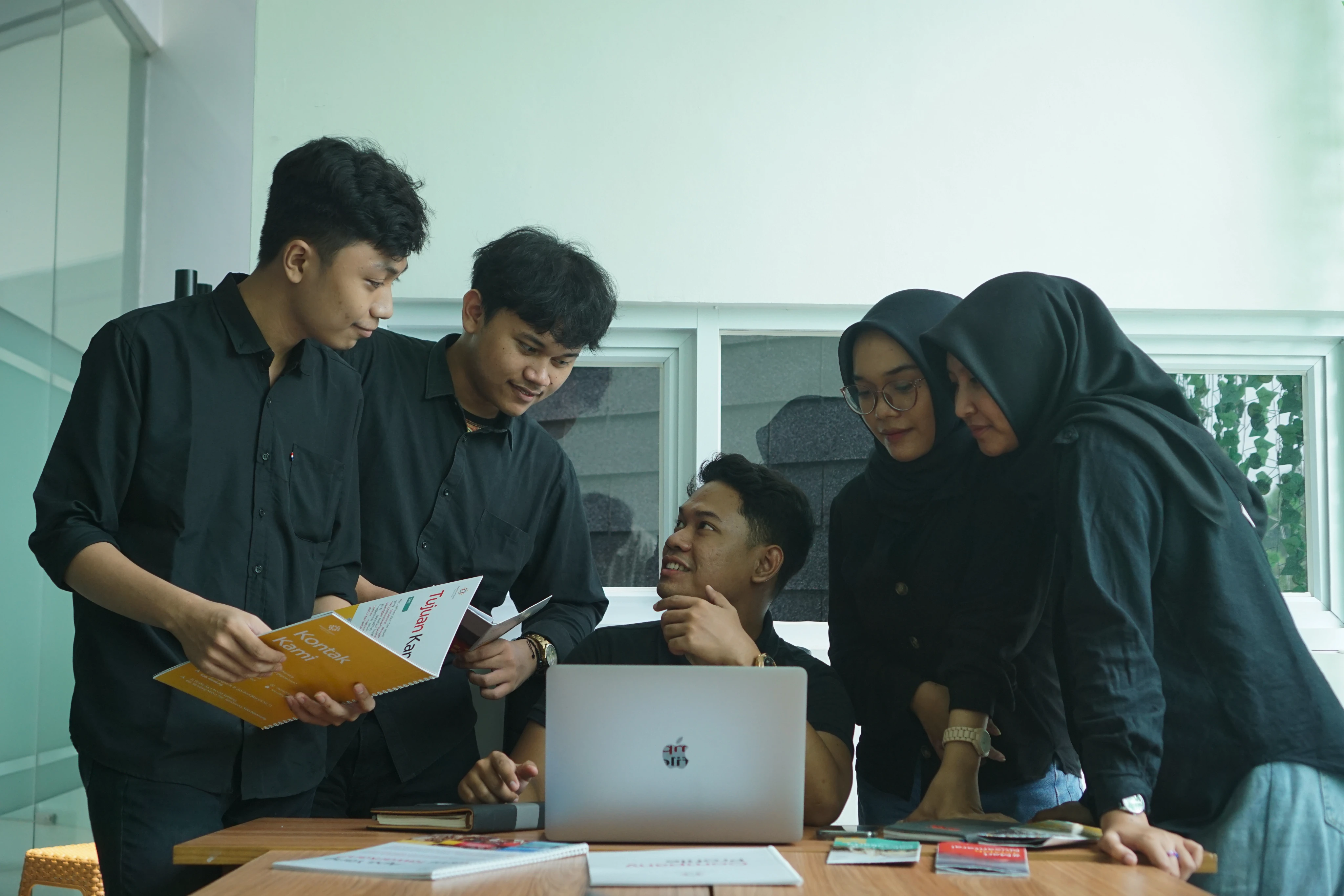 Arsalynk team collaborating around a laptop